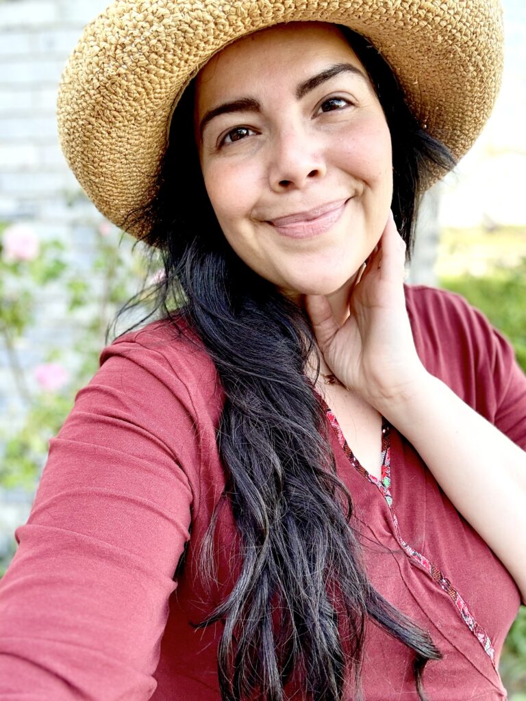 A young woman holding her face smiling kindly, full of hope