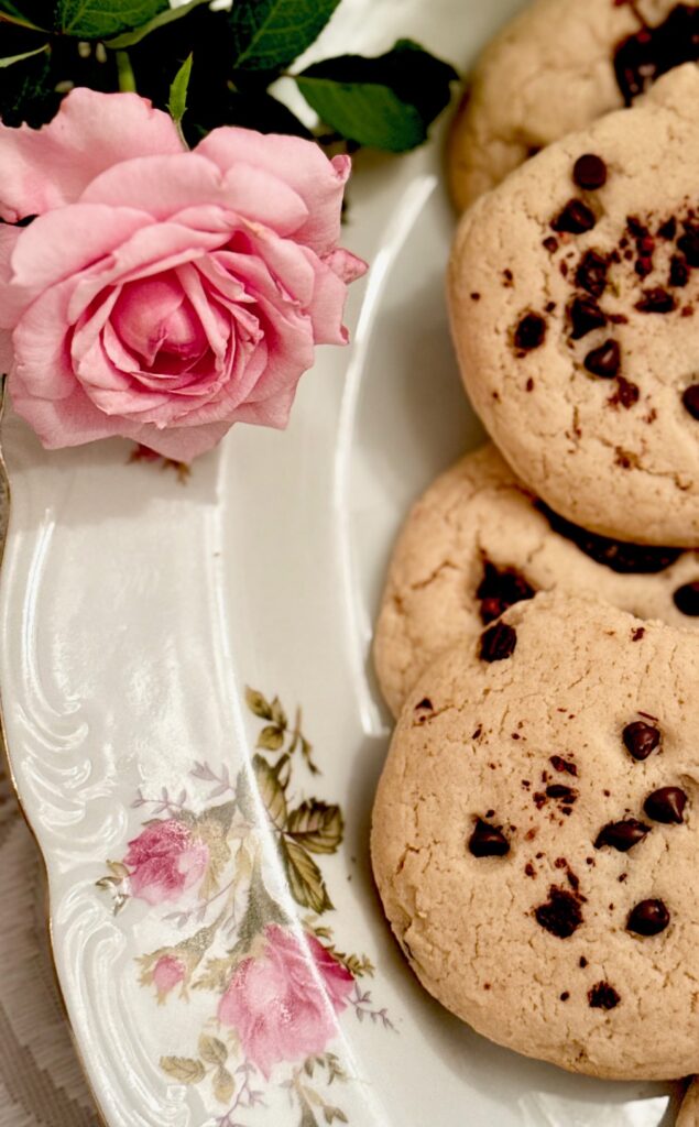 Beautiful Belinda Rose sitting next to a platter of chocolate chip cookies 