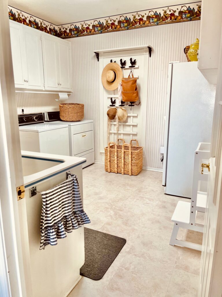 a beautiful vintage cottagecore laundry room with vintage picnic and stripped wallpaper