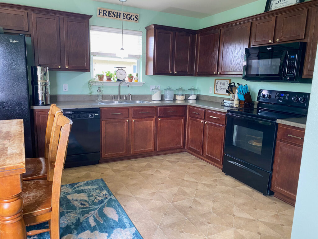 a darling kitchen open floor concept in pretty soothing colors, blue and green hues