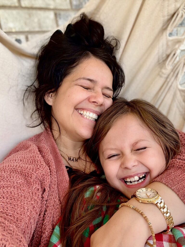 A young mother and daughter happily smiling